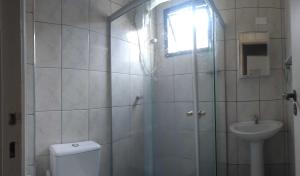 a bathroom with a shower and a toilet and a sink at Apartamento em Ubatuba próximo a praia! in Ubatuba