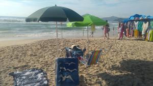 a beach with umbrellas and chairs on the beach at Apartamento em Ubatuba próximo a praia! in Ubatuba