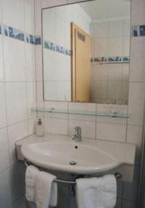 a bathroom with a sink and a mirror and towels at Apart Vita Nova in Ischgl