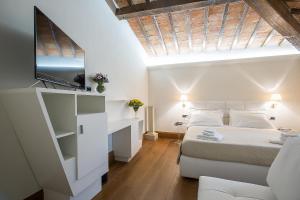 ein Schlafzimmer mit einem Bett und einem TV an der Wand in der Unterkunft Relais Hotel Centrale "Dimora Storica" in Florenz