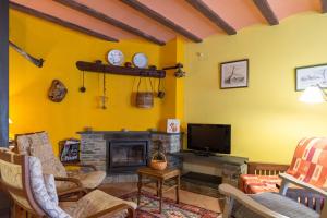 a living room with a tv and a fireplace at La Coberta-Lo Paller del Coc in Rialp
