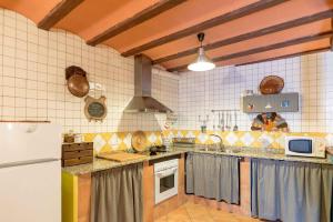 a large kitchen with a counter and a refrigerator at La Coberta-Lo Paller del Coc in Rialp