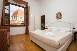 a bedroom with a large bed and a window at Relais Hotel Centrale "Dimora Storica" in Florence