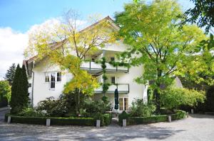 una casa blanca con árboles delante de ella en Hotel Krone Überlingen am Ried, en Singen