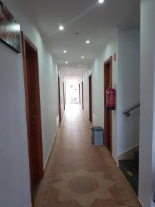 a hallway with a long corridor with many doors at Sába-Ház in Balatonboglár