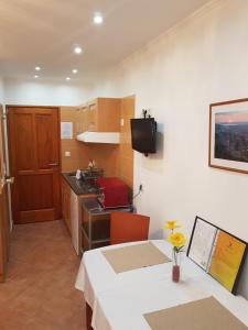 a room with a table and a kitchen with a sink at Sába-Ház in Balatonboglár