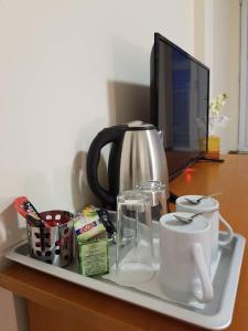 a tray with a tea pot and a kettle on a desk at Rooftop Oscar Rooms in Sofia