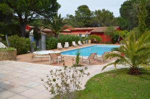 a patio with a table and chairs next to a pool at Les Gîtes Les Mayombes in Roquebrune-sur-Argens