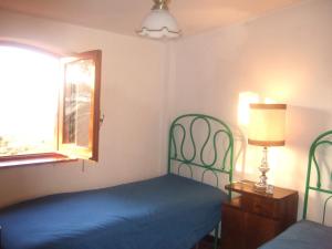 ヴィッラフランカ・ティッレーナにあるVilla Serroのベッドルーム(青いベッド1台、窓付)