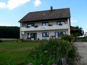 a white house with windows and flowers in front of it at Landgasthof Zum Schloss in Birgland