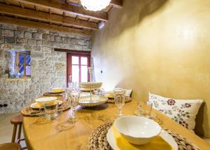 a wooden table with glasses and plates on it at Rodi in Rhodes Town