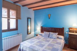a blue bedroom with a bed with blue walls at La Coberta-Lo Paller del Coc in Rialp