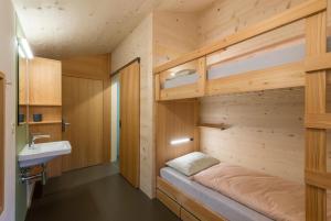 Cette petite chambre comprend un lit et un lavabo. dans l'établissement Jugendherberge Trin, à Trin