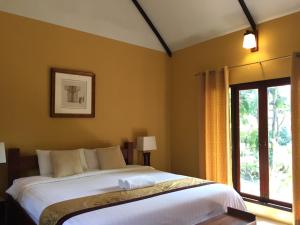 a bedroom with a large bed and a window at Baan Thai House in Phra Nakhon Si Ayutthaya