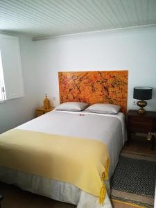 a bedroom with a large bed with a yellow headboard at Casinhas da Ajuda nº 27 in Lisbon