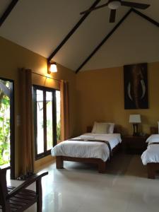 a bedroom with two beds and a large window at Baan Thai House in Phra Nakhon Si Ayutthaya