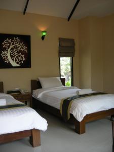 a bedroom with two beds and a window at Baan Thai House in Phra Nakhon Si Ayutthaya