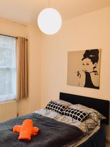 Un dormitorio con una cama con un objeto naranja encima. en Mapesbury Hostel London, en Londres