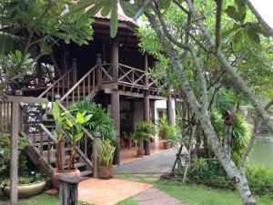 a resort with a wooden walkway in front of a building at Baan Thai House in Phra Nakhon Si Ayutthaya