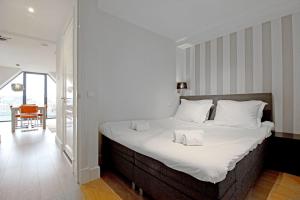 アムステルダムにある2 bedroom loft near Rijksmuseumのベッドルーム(白いシーツを使用した大型ベッド1台付)