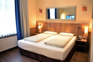 a hotel room with two beds and a mirror at Arthotel Munich in Munich