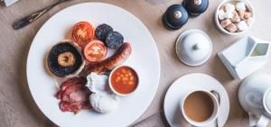 a plate of breakfast foods and a cup of coffee at The Swan Hotel in Southwold