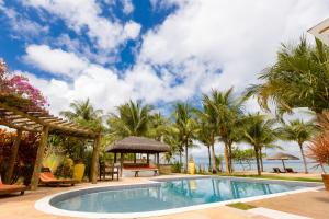 una piscina con palme presso il resort di Pousada Denada a Barra Grande