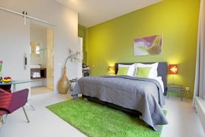 a bedroom with a bed and a green wall at Eastendroom in Amsterdam
