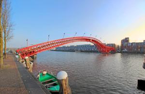 a red bridge over a river in a city at Eastendroom in Amsterdam