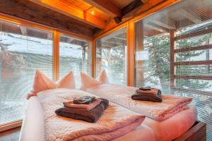 una camera con letto e cuscini di fronte a una finestra di Chalet Schwalbennest a Zermatt