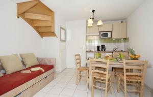 a small apartment with a kitchen and a dining table at Résidence Odalys Le Hameau du Lac in Rignac - Aveyron