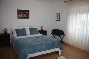 una camera da letto con un letto con una coperta blu di Quinta Teresinha a Silves Altre 33 foto