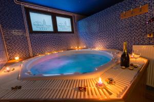 a bathroom with a tub with candles and wine glasses at Divčibarski Vajati in Divčibare