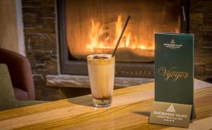 a drink sitting on a table next to a box at Divčibarski Vajati in Divčibare