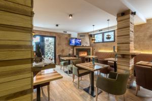 a restaurant with tables and chairs and a fireplace at Divčibarski Vajati in Divčibare
