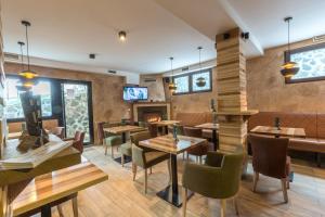 a restaurant with tables and chairs and a fireplace at Divčibarski Vajati in Divčibare