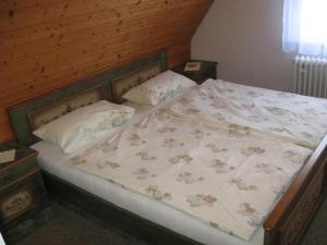 uma cama com cabeceira em madeira e almofadas em Assmanns Ferienwohnungen Ost em Miltenberg