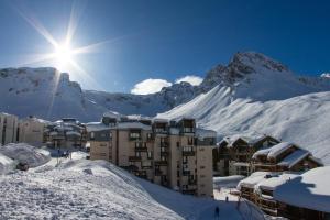 a building in the snow with a mountain in the background at Tignes duplex luxe parking 6-8 p in Tignes