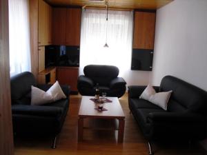 uma sala de estar com dois sofás pretos e uma mesa de centro em Assmanns Ferienwohnungen Ost em Miltenberg