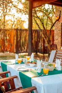 a table with white tablecloths and napkins on it at La Kruger Lifestyle Lodge - No Loadshedding in Marloth Park