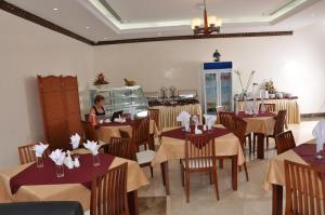 a woman sitting at a table in a restaurant at Akas-Inn Hotel Apartment in Dubai