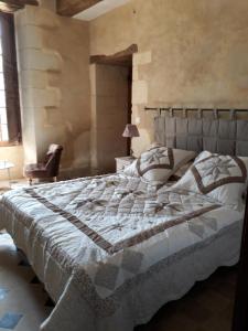 a bedroom with a large bed and a chair at Manoir de La Fontaine Du Chêne in Coutures