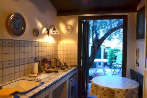 una cucina con lavandino, tavolo e finestra di Guest House Spinuzza a Cefalù