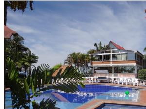 a building with a swimming pool in front of a building at Palestina Ecohotel in Chinchiná
