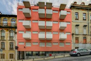 a red building with windows on a street at Hotel Principe Real in Lisbon