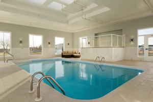 a large swimming pool with blue water in a room at Days Inn & Suites by Wyndham Brooks in Brooks