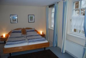 een bed in een kamer met 2 ramen bij Kronenhof - Wein und Ferien in Gau-Algesheim
