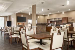 a restaurant with tables and chairs and a bar at Days Inn & Suites by Wyndham Brooks in Brooks
