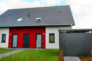 Maison rouge et blanche avec toit noir dans l'établissement Ferien_HAUS LIMERICK, à Göhren-Lebbin