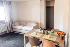 a living room with a table and chairs and a couch at Residence Des Alpes in Canazei